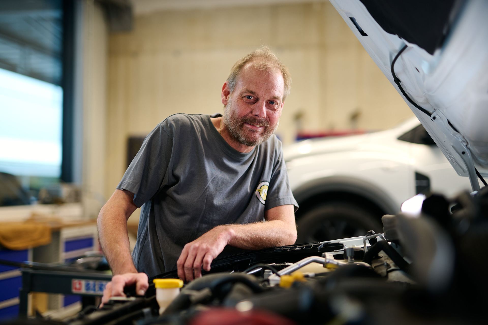 Kfz-Meister von Motor Mayerhofer am geöffneten Motorraum
